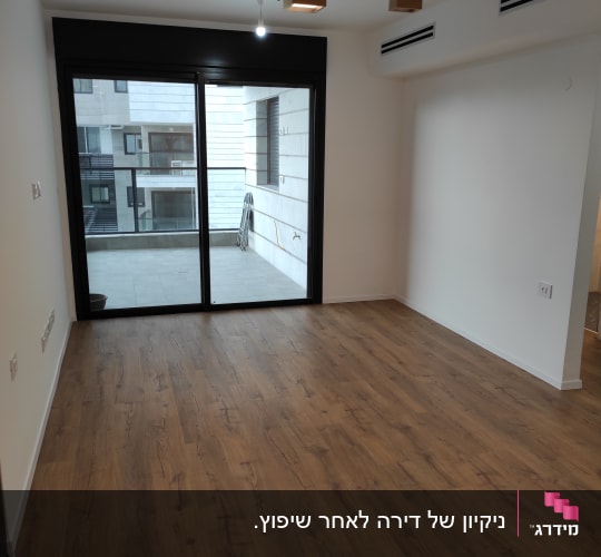 רצפה נקייה מעץ ליד חלון זכוכית גדול